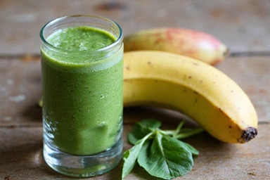 Green smoothie ingredients like spinach, banana, and apple